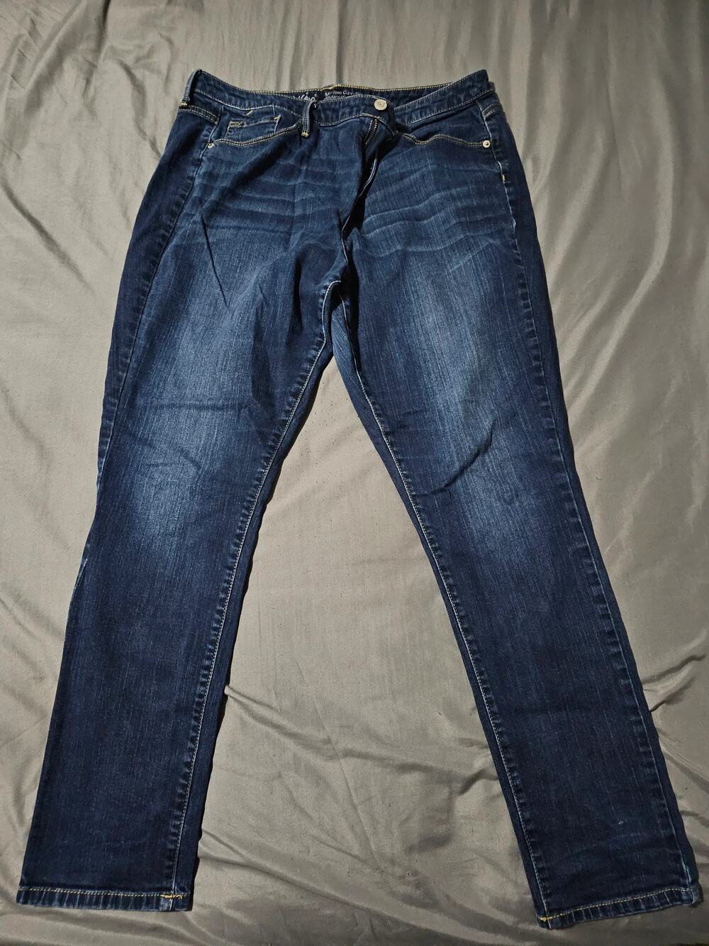 Dark wash denim jeans with contrast stitching and rolled hem detail